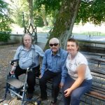 Pracownik GOPS i dwóch seniorów na ławce przy Kaplicy w Kęble.
